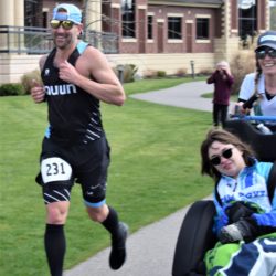 Runner Athletes Pushing Rider Athlete Through Race Course